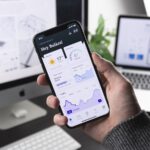 Developer using visual drag and drop no-code app builder on computer screen to create mobile application