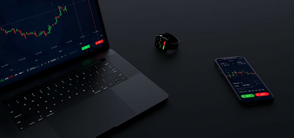 Person monitoring cryptocurrency trading dashboard on multiple screens with real-time price charts