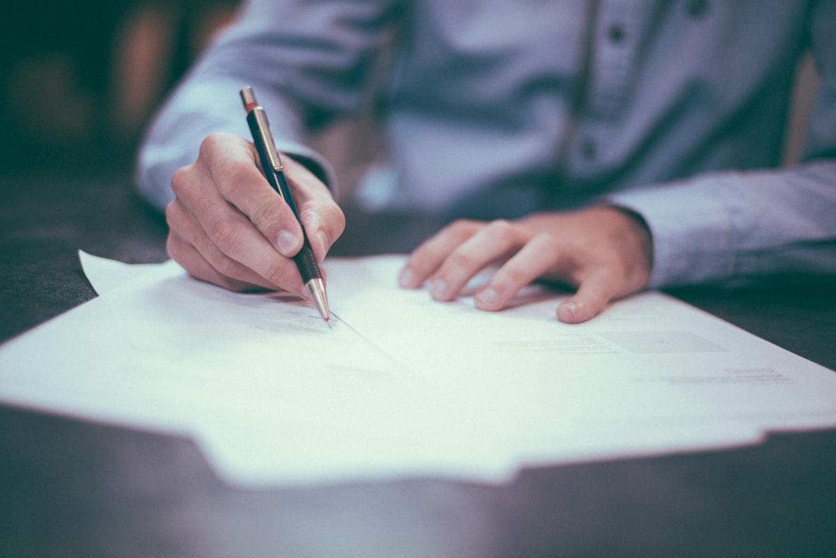 Sports contract signing concept with pen on document and stadium lights in background