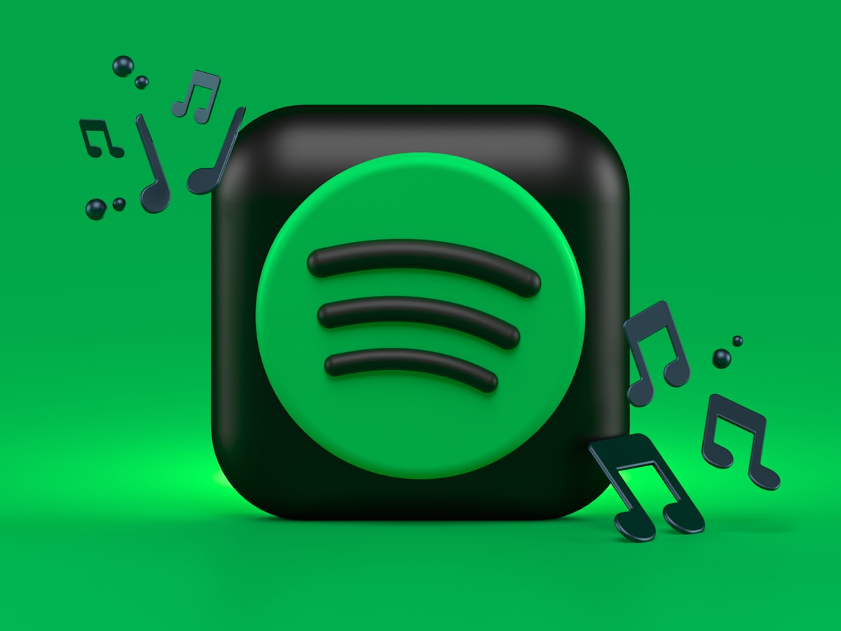 Musician analyzing Spotify streaming revenue dashboard on laptop with charts and analytics