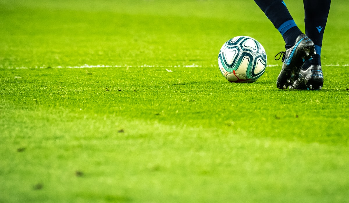 Person watching live sports on smartphone with stadium and football match on screen