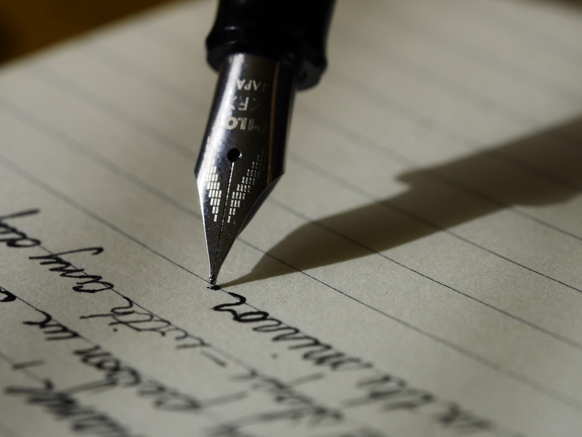 Writer using AI software on laptop to create and edit ebook manuscript with books in background